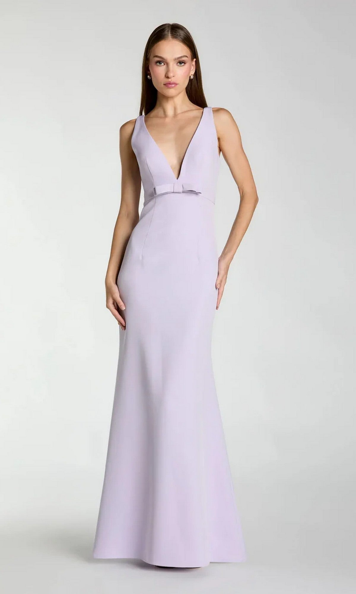 A woman stands against a plain background wearing the Mac Duggal 2371, a sleeveless, floor-length light purple crepe formal dress featuring a deep V-neckline and fitted silhouette.